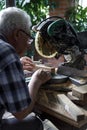 Mature man preparing lumber befor cut it with sliding compound miter saw outdoors. Home carpentry workshop