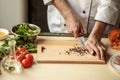 Mature man professional chef cooking meal indoors Royalty Free Stock Photo