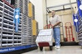 Mature man pushing handtruck in hardware store