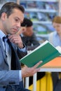 Mature man reading book in library Royalty Free Stock Photo