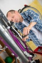 Mature man repairing bicycle in workshop Royalty Free Stock Photo