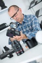 Mature man repairing dslr camera in workshop