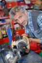 Mature man repairing weed whacking machine