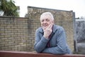 Mature man resting on a wooden gate outdoors Royalty Free Stock Photo