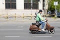 Mature man in retro outfit riding vintage scooter vespa on empty city street in Dorcol, Belgrade