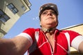 Mature Man Rides Bicycle Downtown Seen from Low Angle