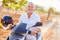 Mature Man Riding Motor Scooter Along Country Road Royalty Free Stock Photo
