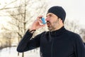 mature man running at winter in park have some breathing difficulties and using asthma pump Royalty Free Stock Photo