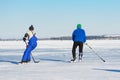 Mature man rushing to the pack while playing hockey on a frozen river Dnepr