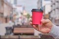 Mature man`s hand holds red paper cup