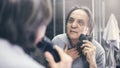 Mature man shaving in front of mirror Royalty Free Stock Photo