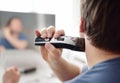 Mature man is shaving off his beard with electric razor at home during quarantine. Handsome bearded man trimming his beard with Royalty Free Stock Photo