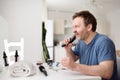 Mature man is shaving off his beard with electric razor at home during quarantine. Handsome bearded man trimming his beard with Royalty Free Stock Photo