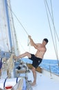 Mature man smiling while hoisting the sail