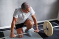 Mature man exercising with weights at the gym