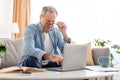 Mature man squinting using laptop, looking at pc screen Royalty Free Stock Photo