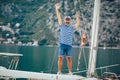 Man standing and laughing at helm of sailboat out at sea on a sunny afternoon Royalty Free Stock Photo