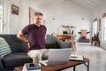 Mature man stretching back while working at home