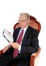 Mature man in suit reading book. Royalty Free Stock Photo