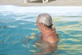 Mature man swimming in pool. Summer vacation and retirement. Mature man at spa resort in summer. Grey hair Royalty Free Stock Photo