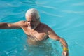 Mature man swimming in pool. Summer vacation and retirement. Mature man at spa resort in summer Royalty Free Stock Photo