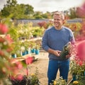 Mature Man With Trolley Outdoors In Garden Centre Choosing Plants  And Buying Rose Royalty Free Stock Photo