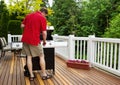 Mature man turning on barbecu grill while outside on open deck Royalty Free Stock Photo