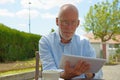 Mature man use tablet . Sitting in the garden Royalty Free Stock Photo