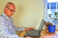 Mature man using a graphic pad and notebook in the home office