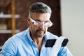 Mature Man Using Magnifying Glasses For Reading Small Text Royalty Free Stock Photo