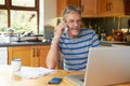 Mature Man Using Mobile Phone Looking At Home Finances Royalty Free Stock Photo