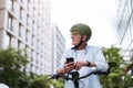 Mature man using mobile phone while riding bicycle in the city Royalty Free Stock Photo