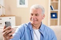 Mature man using video chat on mobile phone Royalty Free Stock Photo