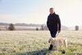 Mature Man Walking Dog In Frosty Landscape Royalty Free Stock Photo