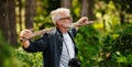 Mature man walking with a stick in a green forest. Weekend hike. Adventure is ageless Royalty Free Stock Photo