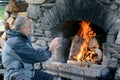 Mature man warm up with fireplace Royalty Free Stock Photo