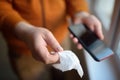 Mature man wipes with a disinfecting cloth heis smartphone after returning home. Safety during COVID-19 outbreak in public places