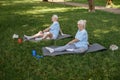 Mature man and woman do yoga exercises sitting on lawn grass Royalty Free Stock Photo