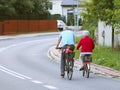 Mature man and woman rides a bicycle among the greens. A healthy and active part of life. Ecological transport for the population.