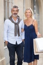 Mature man and woman with shopping bags smiling outdoors