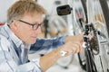 Mature man working on bicycle in workshop Royalty Free Stock Photo