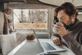 Mature man working on laptop computer inside a camper van with nature outdoors view outside the window. Concept of freedom and Royalty Free Stock Photo