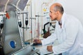 Mature man working on quality of products in winery lab