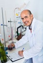 Mature man working on quality of products in winery lab