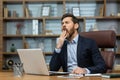 Mature man yawning inside classic office, senior businessman in workplace sleepless and overworked, boss in business Royalty Free Stock Photo