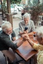 Mature men arm-wrestling while friend making video Royalty Free Stock Photo
