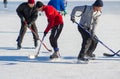 Mature men fighting for the pack while playing hockey on a frozen river Dnepr
