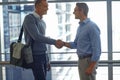 Mature men, handshake or partnership deal in airport lounge, hotel lobby or modern office for financial deal success Royalty Free Stock Photo