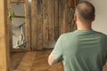 Mature middle aged caucasian man practicing yoga and meditation near mirror with his reflection with wooden background as place