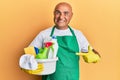 Mature middle east man wearing cleaner apron holding cleaning products smiling happy pointing with hand and finger Royalty Free Stock Photo